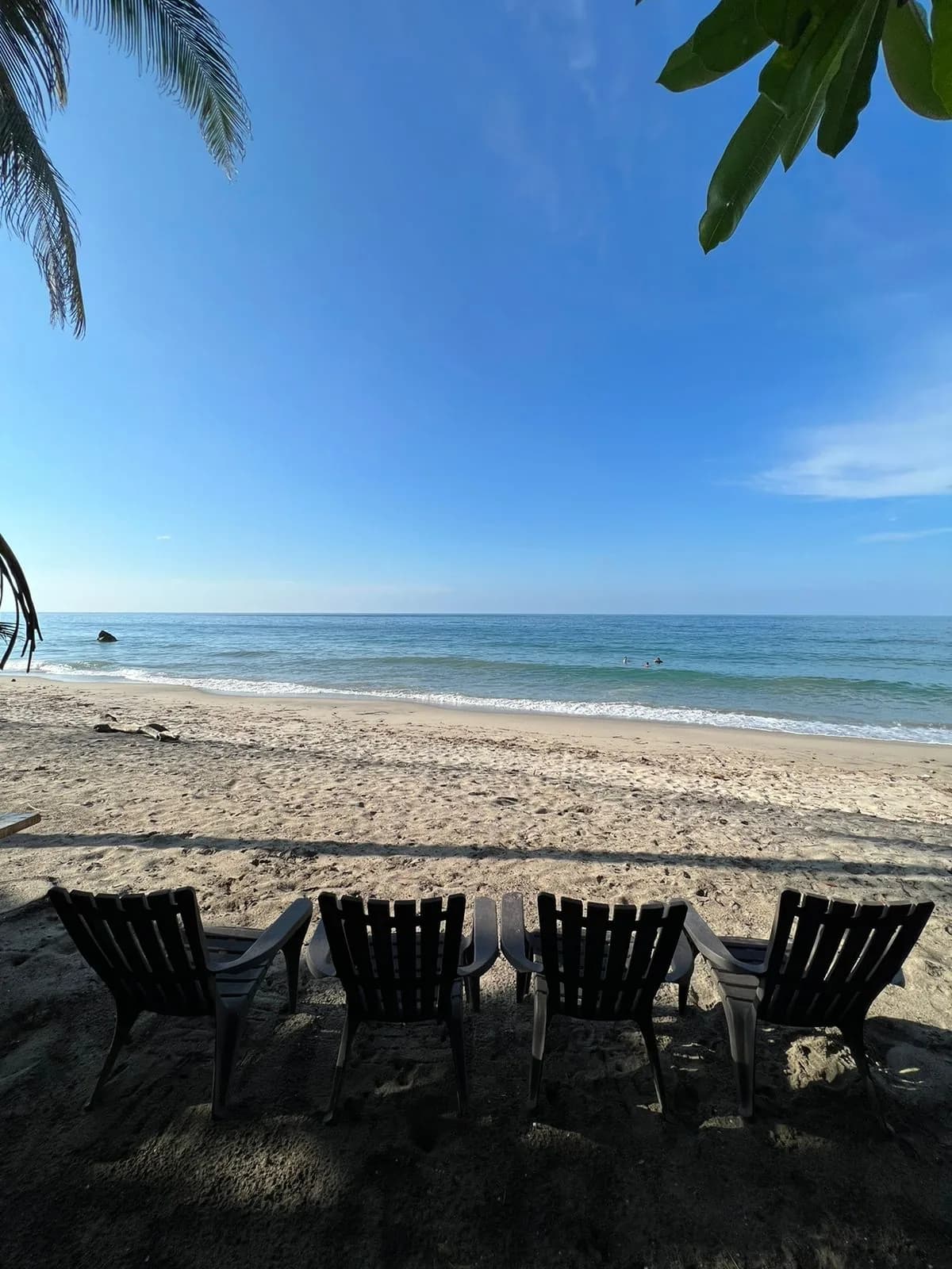 Sillas de madera frente al mar en la playa privada de La Jorará