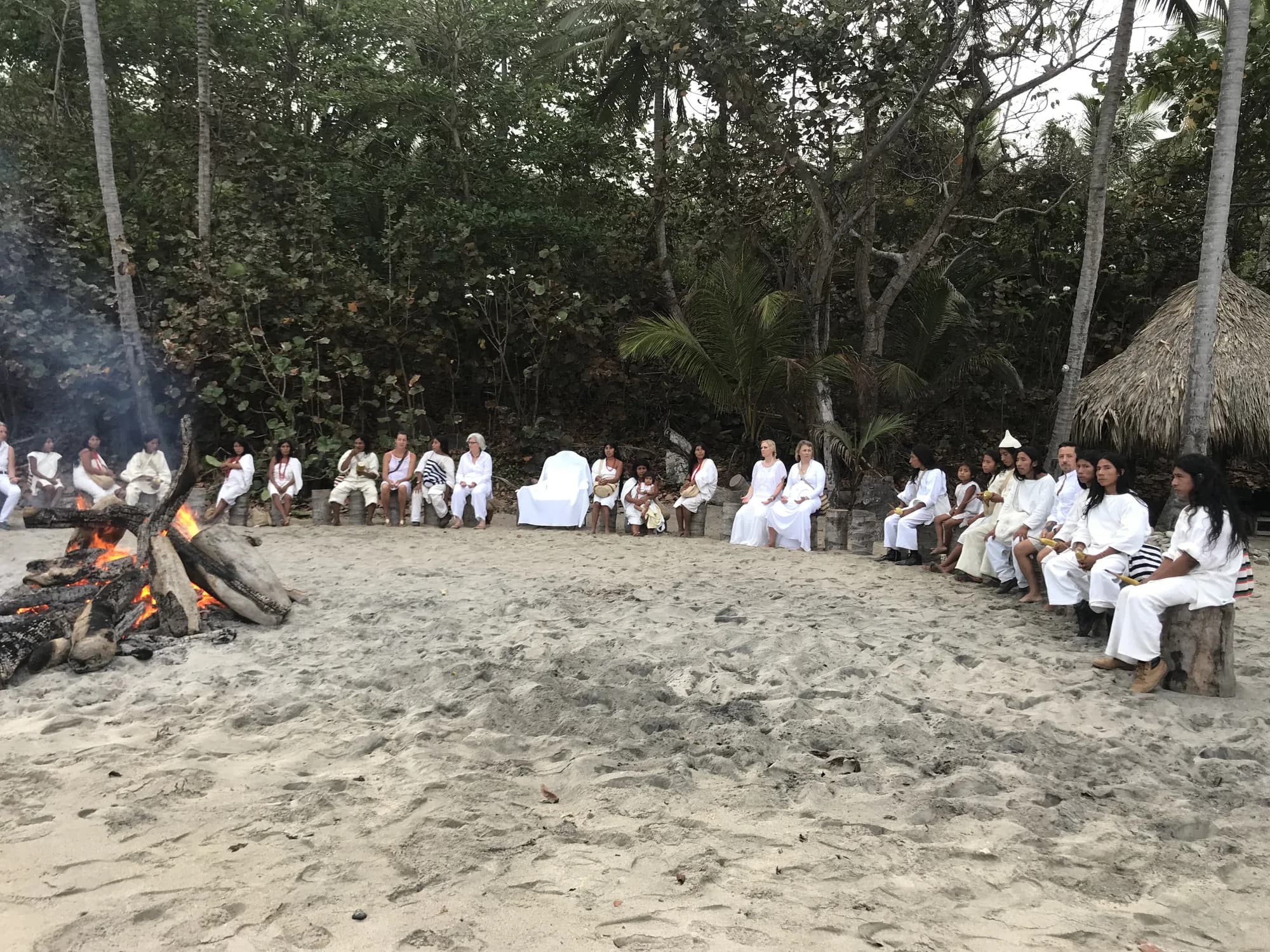 Ceremonia alrededor de una fogata en la playa, al anochecer